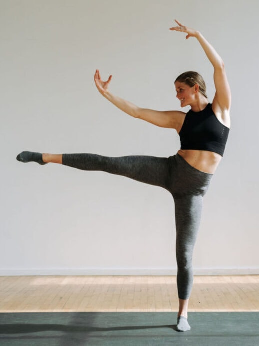 woman performing an arabesque as part of a cardio barre workout