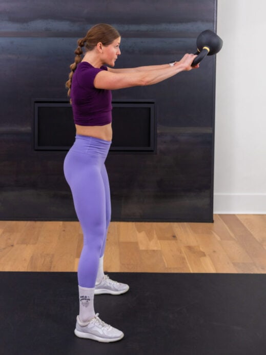 woman performing a kettlebell swing in a beginner workout