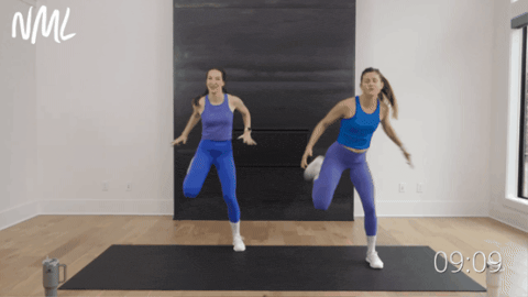 two women performing standing hamstring curls as part of beginner cardio workout