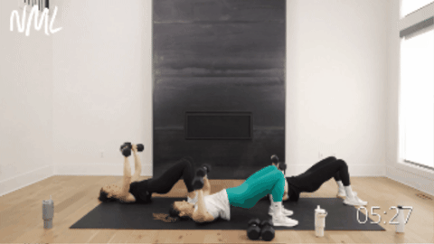 three women performing a combination of glute bridges, chest presses and dumbbell skull crushers as part of dumbbell only workout