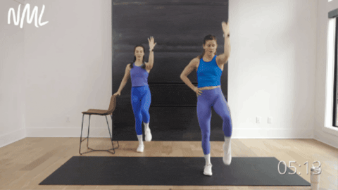 two women performing a knee to elbow crunch and side leg lift as part of pilates ab workout
