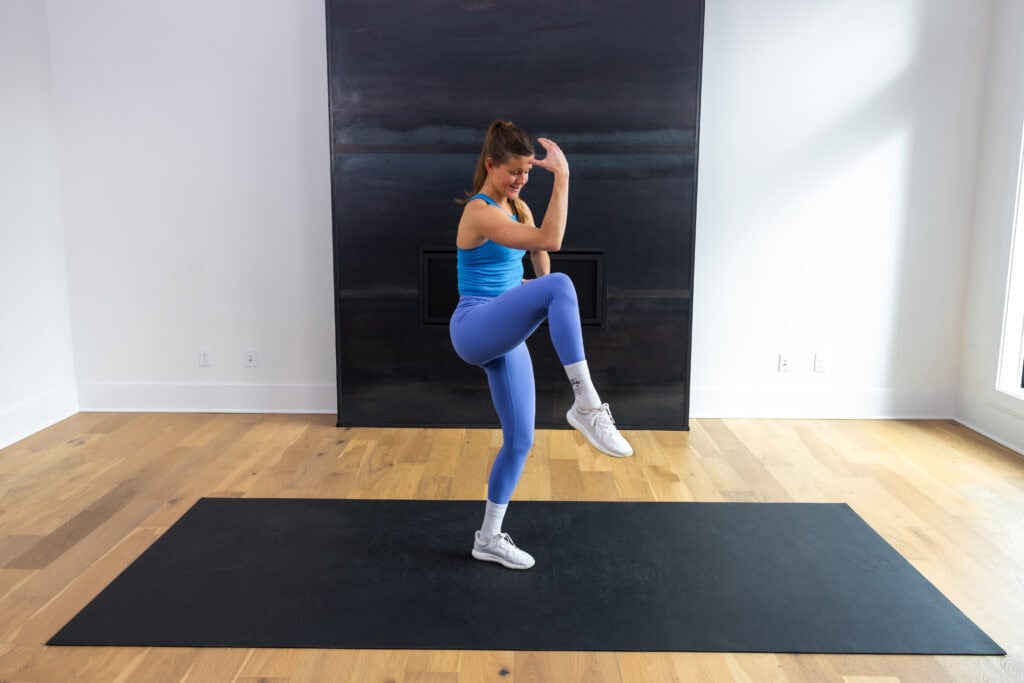 woman performing standing crunch as part of pilates ab workout