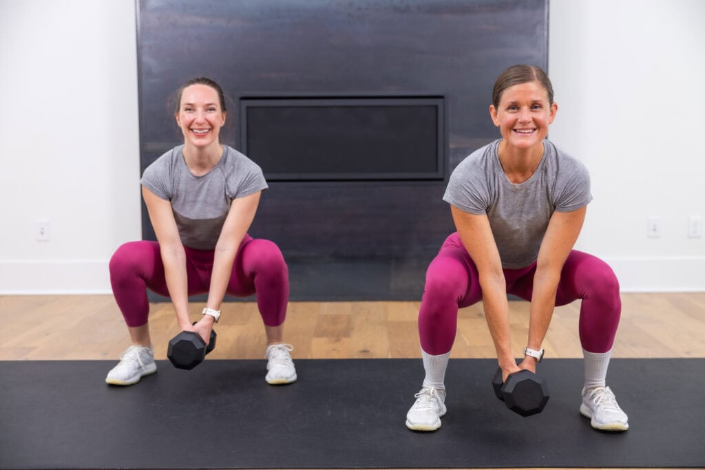 two women performing dumbbell squat as part of zone 2 cardio with weights workout