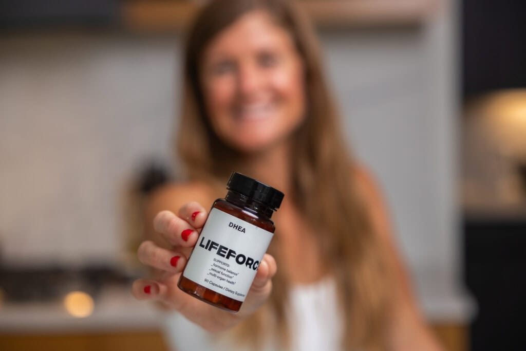 Women holding a lifeforce product in her kitchen. 