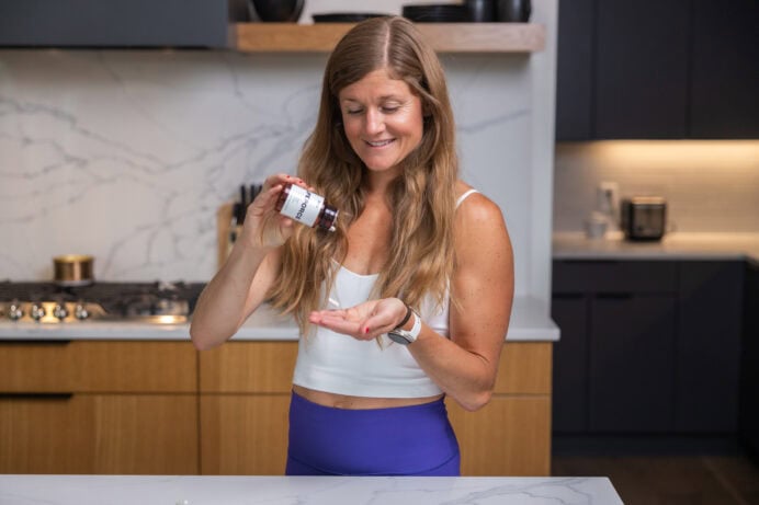 Women in her kitchen taking her lifeforce supplements.