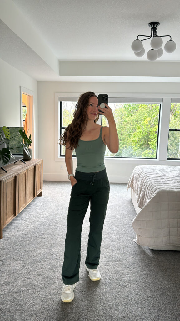 Women wearing green dance studio mid-rise pants with three tank top from lululemon.