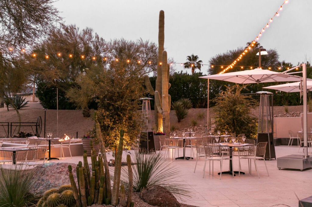 outdoor dining area with tables and string lights at civana wellness resort